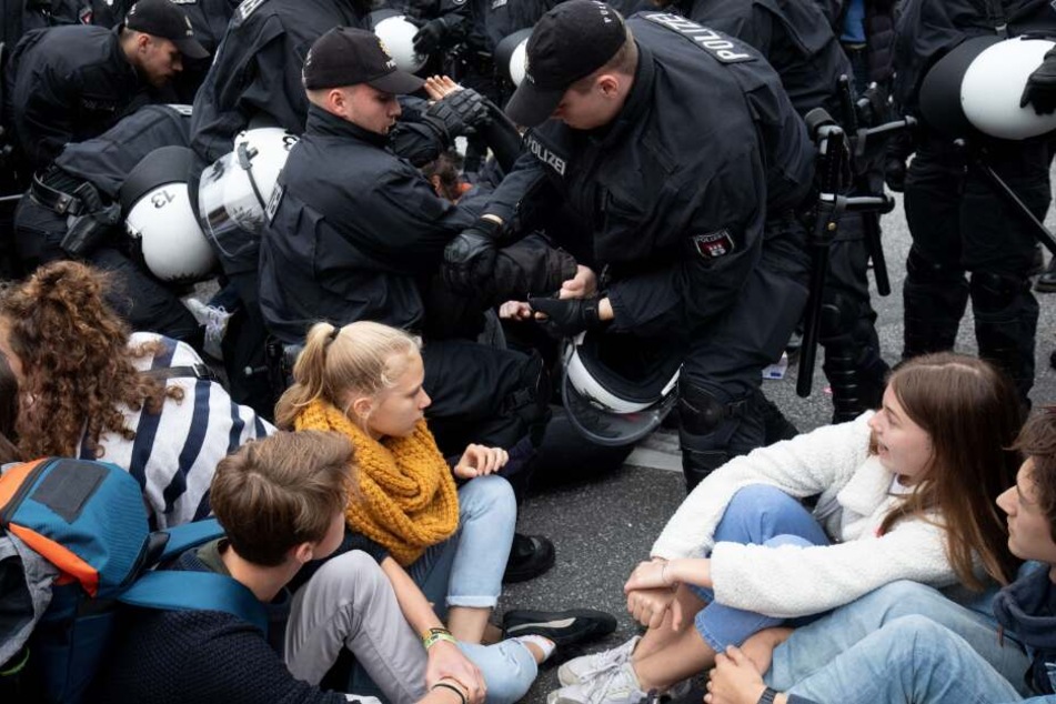 Polizisten lösen eine Sitzblockade auf dem Stephansplatz auf.