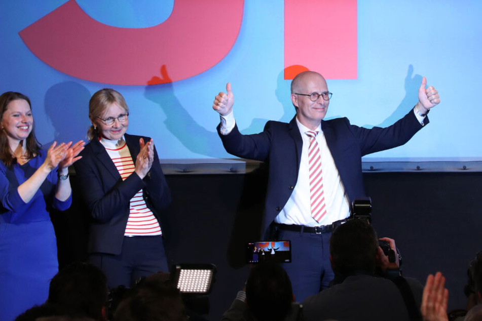 Peter Tschentscher (rechts) jubelt nach der ersten Prognose auf der Wahlparty seiner Partei zusammen mit seiner Ehefrau Eva-Maria (m) und Melanie Leonhard, SPD.