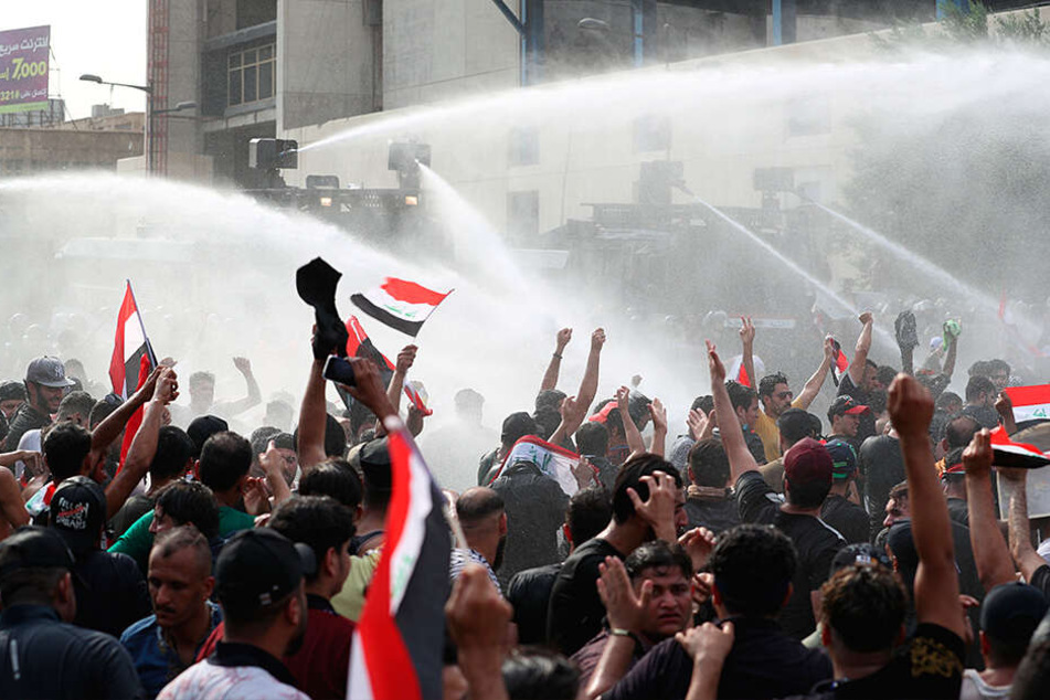 Irakische Sicherheitskräfte gehen mit Wasserwerfern gegen Demonstranten vor, die gegen Korruption und politischen Stillstand auf dem Tahrir-Platz demonstrieren.