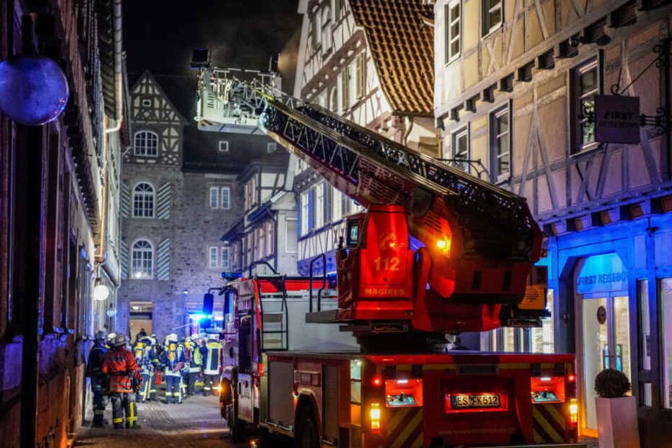 Mit einer Drehleiter löschen die Feuerwehrleute das Fachwerkhaus.