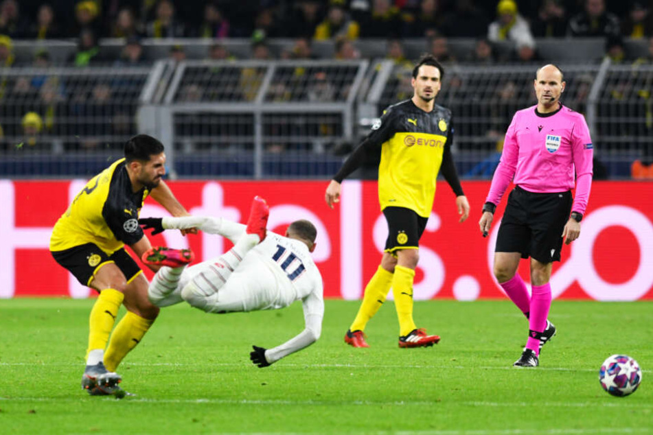 BVB-Kämpfer Emre Can (l.) ließ Neymar (Zweiter von links) in der 19. Minute über die Klinge springen und kam ohne Verwarnung von Schiedsrichter Antonio Mateu Lahoz (r.) davon.