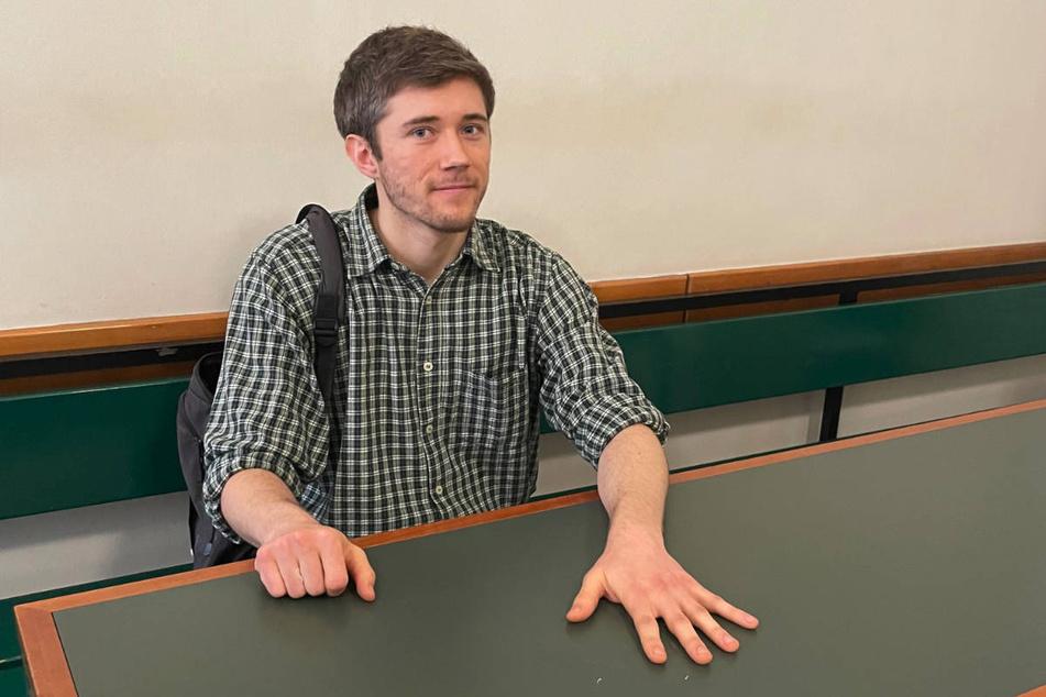 Henning Jeschke (23) hat sich am Donnerstag bei seiner Verhandlung am Amtsgericht Tiergarten mit der linken Hand auf dem Tisch der Anklagebank festgeklebt.