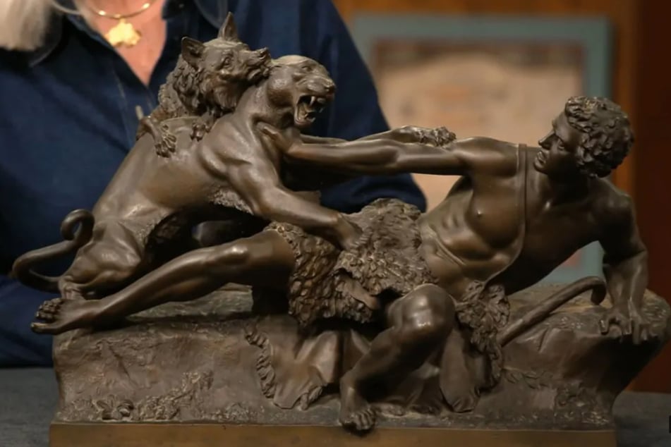 Die massive Bronze zeigt eine beeindruckend detaillierte Kampfszene zwischen einem Hirten mit seinem Hund und einem Panther.