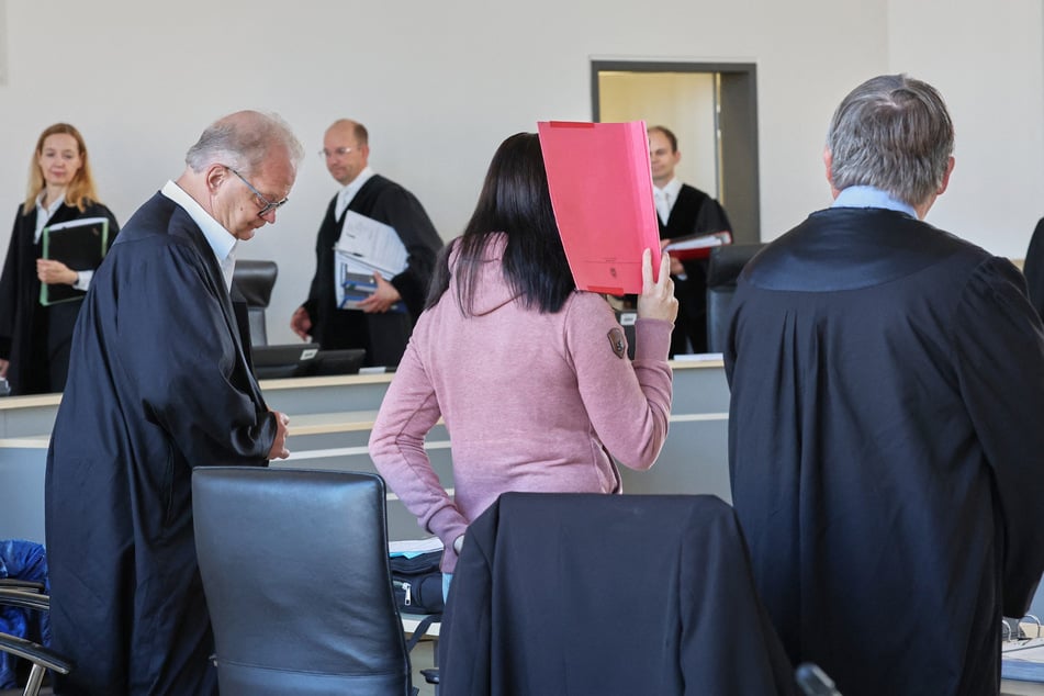 Thomas Löcker (l-r), Anwalt, die Angeklagte und Andreas Ohm, Anwalt warten auf die Fortsetzung des Prozesses.
