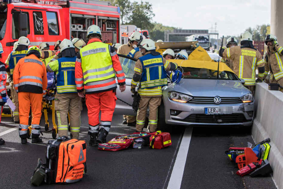 Feuerwehrleute befreien einen eingeklemmten Insassen aus dem Unfallfahrzeug.