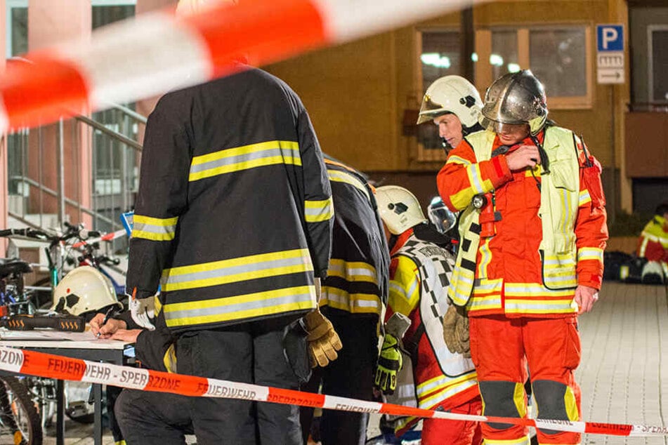 Einsatzkräfte der Feuerwehr werten die im Hausflur genommenen Proben aus.