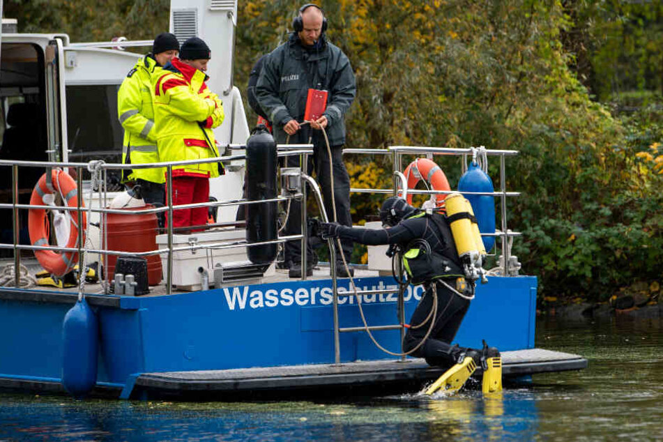Ein Polizeitaucher geht ins Wasser, um nach dem Mädchen zu suchen.