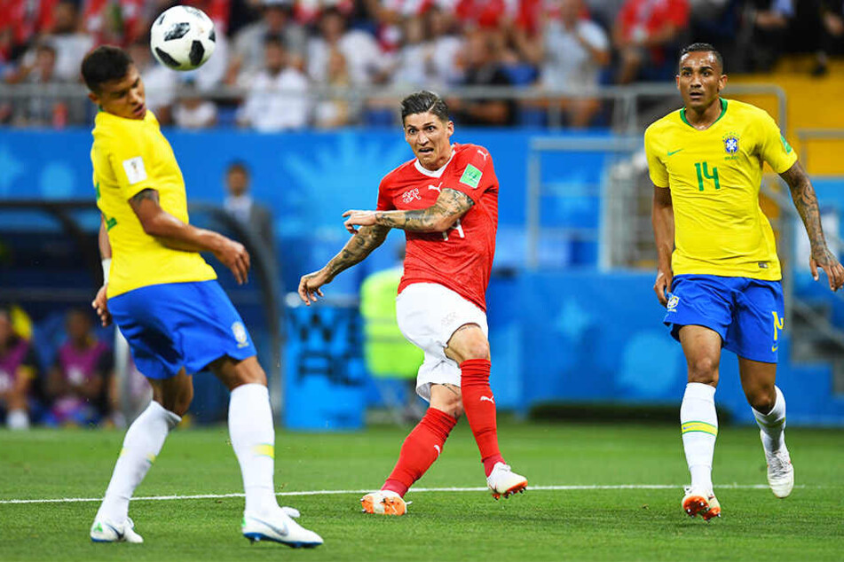 Der Schweizer Steven Zuber (m.) schießt Brasiliens Thiago Silva (l.) ab. Danilo (r.) schaut gebannt zu.