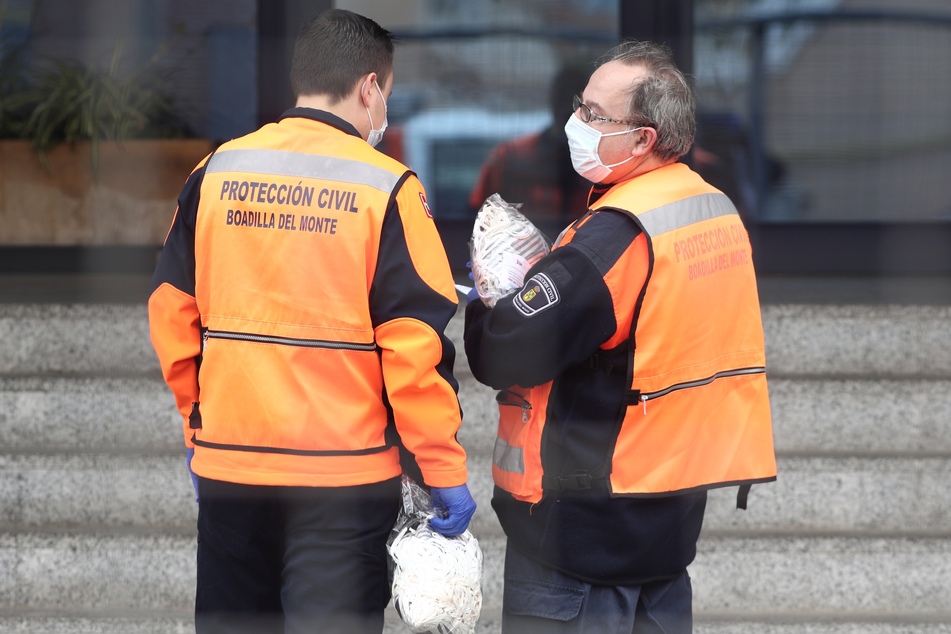 Zwei Beamte des Katastrophenschutzes bringen Masken in das Los Angeles Seniorenheim in Getafe, Madrid.