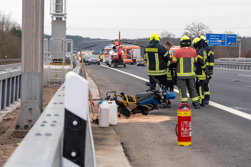 Unfall auf der A3: Feuerwehrleute neben dem beteiligten Kleinkraftrad eines 20-Jährigen.