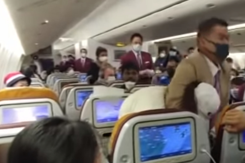 Als eine Frau in einem Flugzeug von Thai Airways hustete, wurde sie von einem Mitarbeiter in den Schwitzkasten genommen.