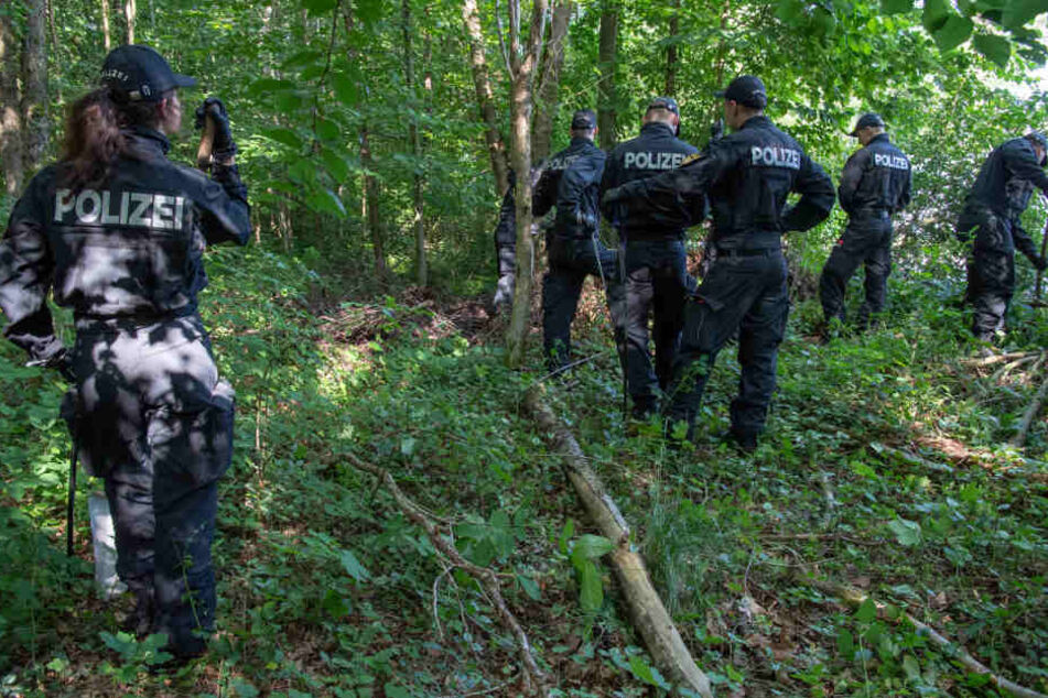 Polizisten suchen in einem Waldstück bei München nach zwei Leichen.