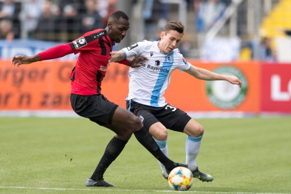 CFC-Riese Tarsis Bonga und TSV 1860 München-Spieler Phillipp Steinhart kämpfen um den Ball.