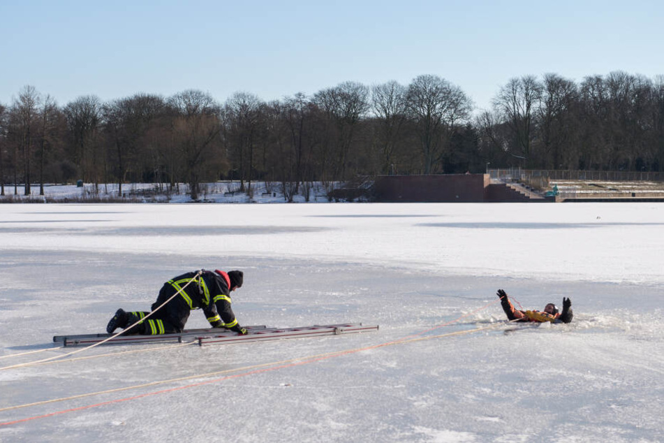 Ein Feuerwehrmann kommt bei einer Übung einem Mann zu Hilfe. (Archivbild)