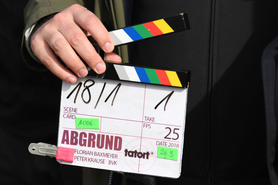 Ein Kameraassistent hält eine Filmklappe in seiner Hand.