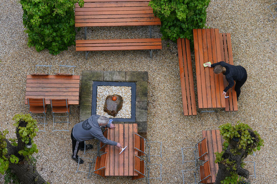 Die Tische im Biergarten des Restaurants "Maybach" im Stadtteil Eimsbüttel werden gereinigt. Hamburger Gastronomen dürfen ihre Außenbereiche wieder öffnen.