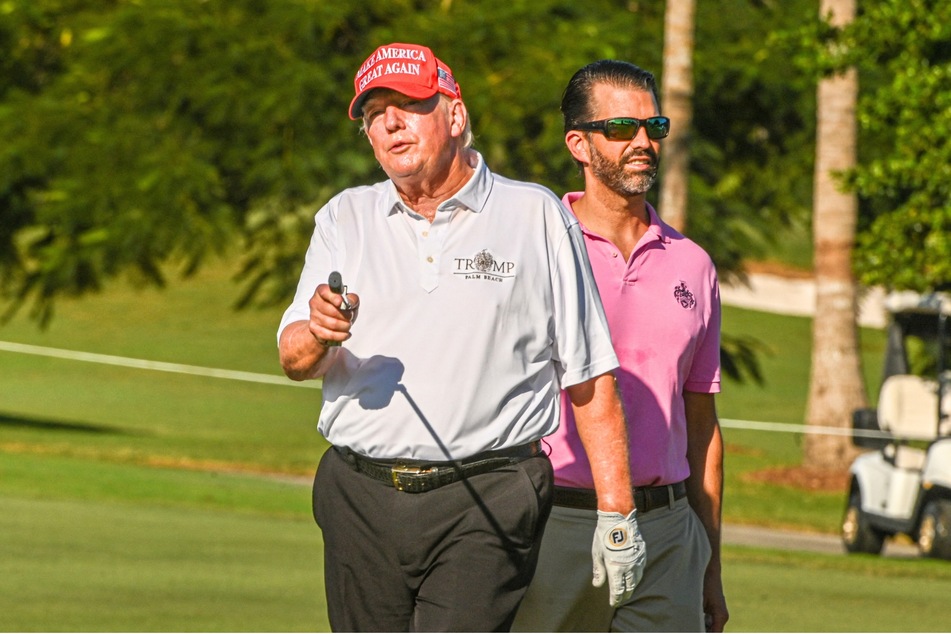Donald Trump (l.) and his son, Donald Trump, Jr., playing golf at Trump National Doral Miami golf club on October 27, 2022.