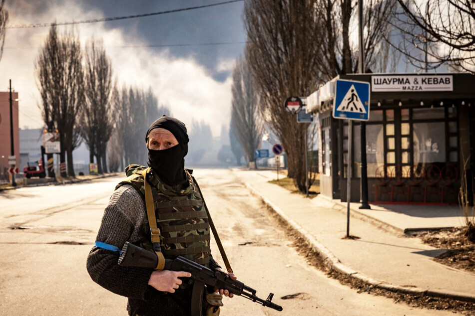 Ein ukrainischer Soldat beobachtet das Geschehen auf einer Straße.