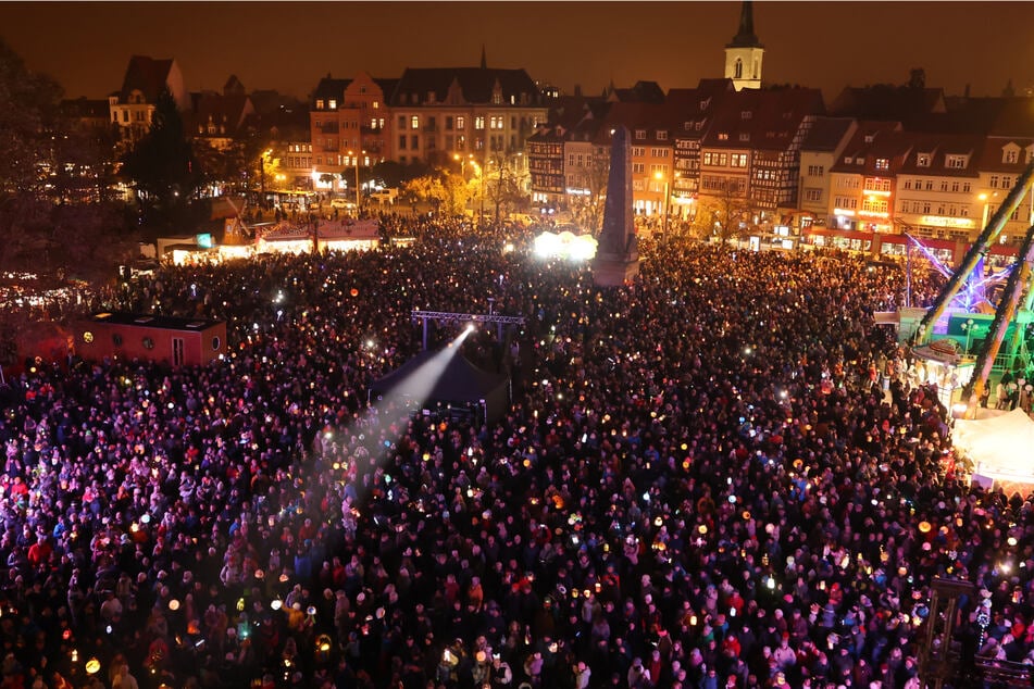 Zahlreiche Menschen haben sich auf dem Erfurter Domplatz versammelt und dort ihre Laternen geschwenkt.