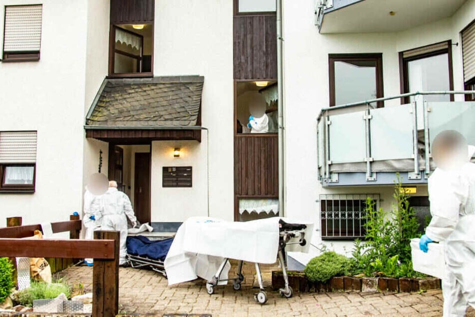 Mitarbeiter der Spurensicherung stehen vor einem Haus, in dem die beiden Menschen gewaltsam getötet wurden.