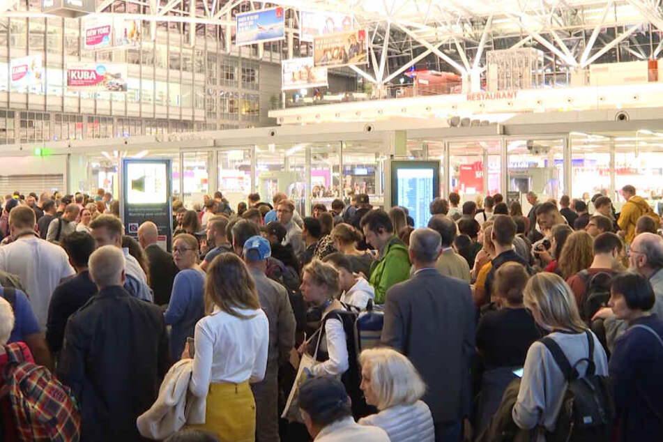 Zahlreiche Passagiere stehen im Hamburger Flughafen.