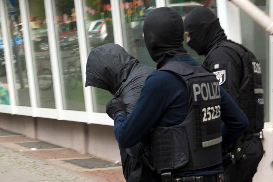 Polizeibeamte führen einen Mann ab. Dreieinhalb Monate nach dem spektakulären Diebstahl einer 100-Kilo-Goldmünze aus dem Berliner Bode-Museum im März 2017 hat die Polizei zwei Verdächtige festgenommen. (Archivbild)