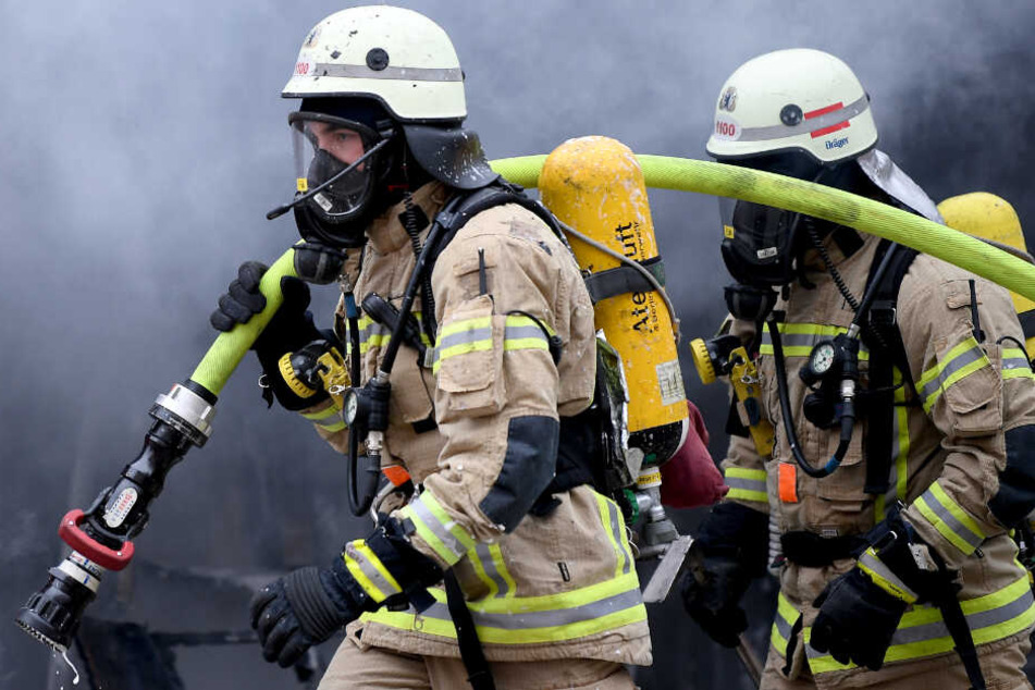 Zwei Feuerwehrleute rücken mit einem Schlauch an. (Symbolbild)
