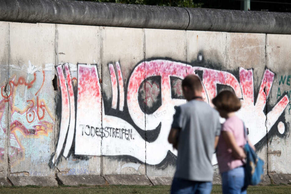 Touristen besichtigen auf dem Gelände der Gedenkstätte Berliner Mauer.