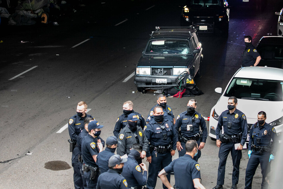 Investigators survey the scene of the crash in the tunnel where many people experiencing homelessness were taking shelter in tents.