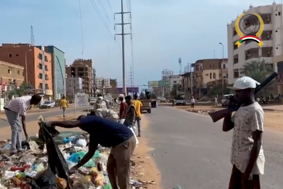 RSF-Truppen zwingen Anwohner für ein Propaganda-Video, die verwüsteten Straßen zu säubern.