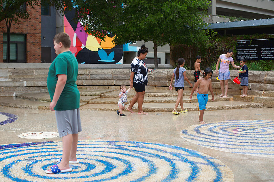 People in San Antonio try to beat the summer heat in public fountains.