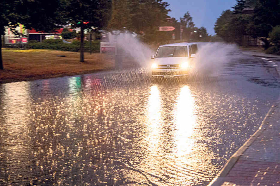 In Bischofswerda bahnt sich ein Fahrzeug den Weg durch die Wassermassen.