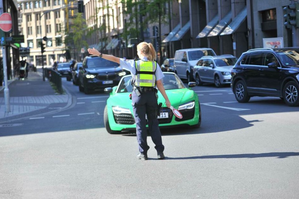 Eine Polizistin winkt einen Audi R8 zur Kontrolle.