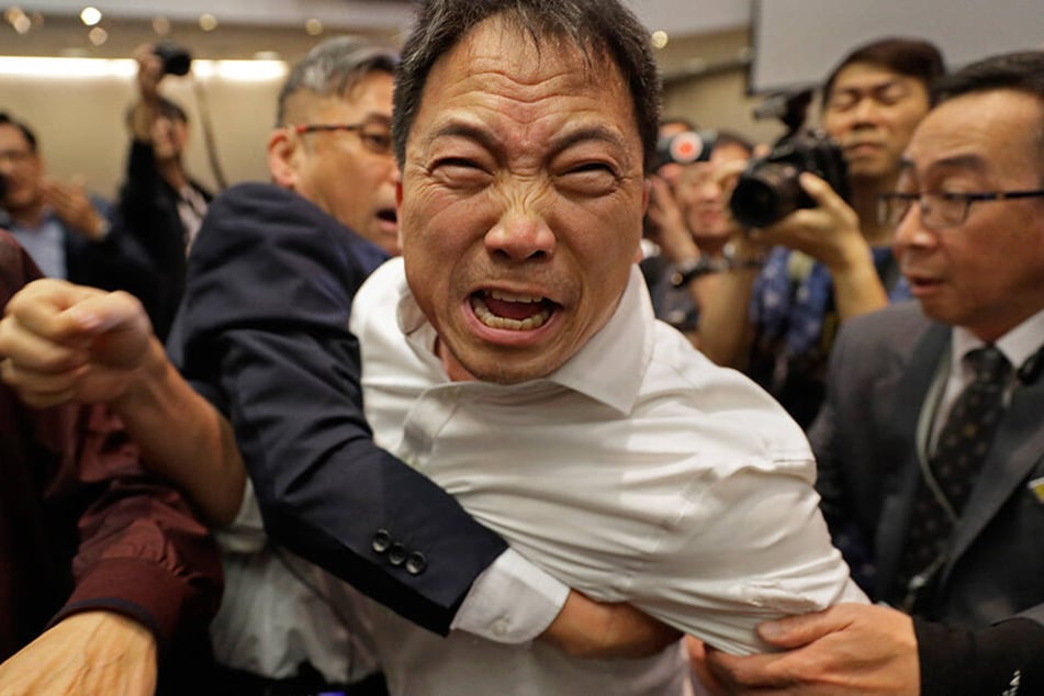 Sicherheitspersonal hält den Abgeordneten des demokratischen Lagers, Wu Chi-wai (M), bei einem Streit mit Pro Chinesischen Abgeordneten im Parlament, dem Legislativrat der Sonderverwaltungszone Hong Kong, fest.
