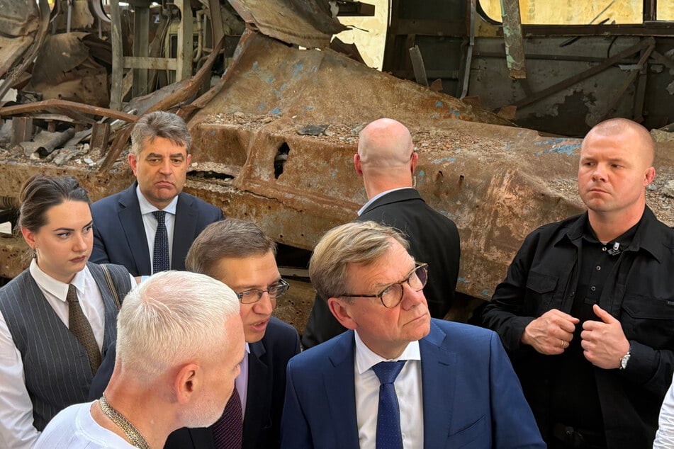 Johann Wadephul (Mitte r., 63, CDU), Bundesaußenminister, steht mit Ihor Terechow (vorne l.), Bürgermeister von Charkiw, in einem U-Bahn-Depot, das 2022 weitgehend zerstört wurde.