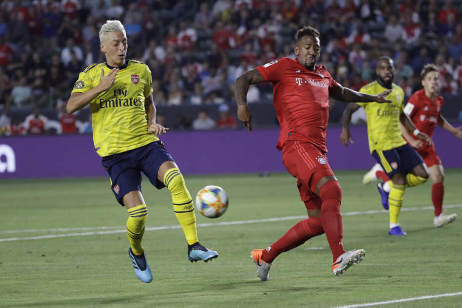 Münchens Jerome Boateng (r) gegen Arsenals Mesut Özil.