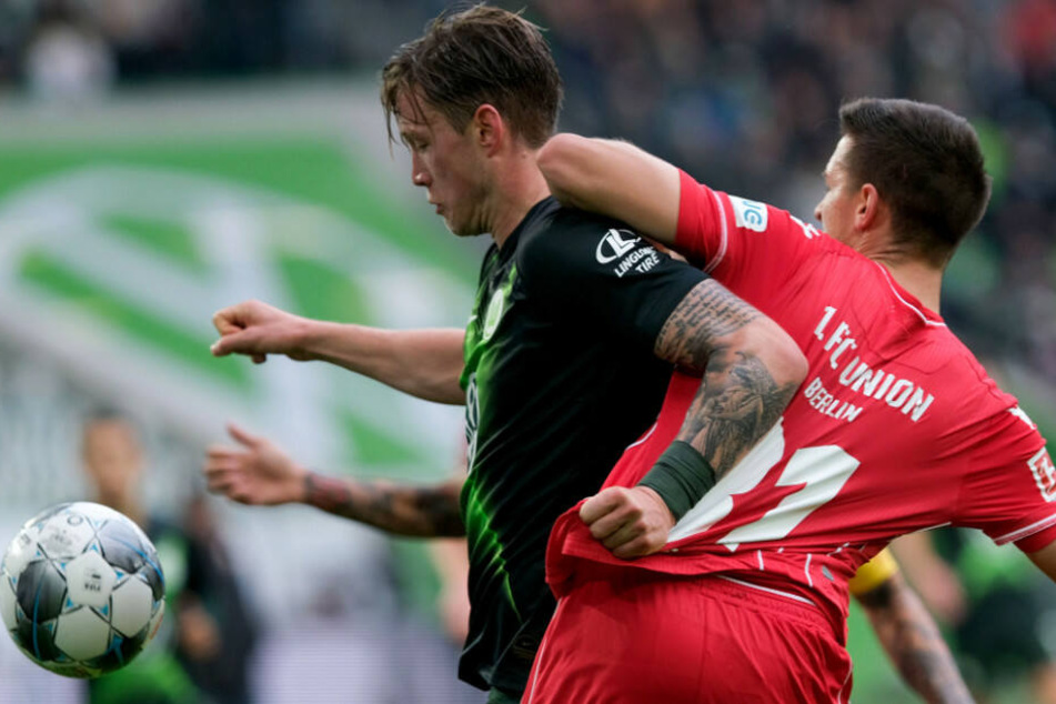 Wolfsburgs Torschütze Wout Weghorst (l.) und Keven Schlotterbeck kämpfen um den Ball.