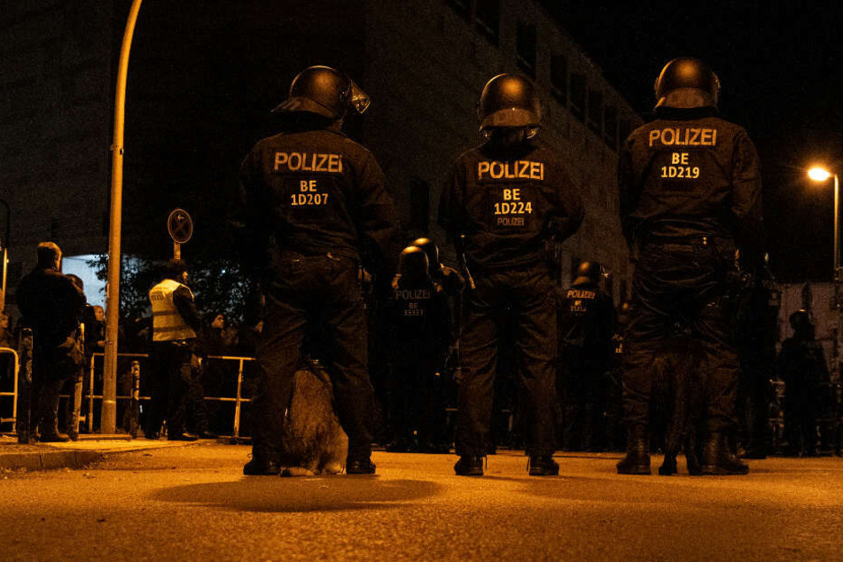 Polizeibeamte mit Hunden stehen unweit der Rigaer Straße Demonstranten gegenüber, die gegen eine Veranstaltung der rechts gerichteten Vereinigung Pegida aus München protestierten.