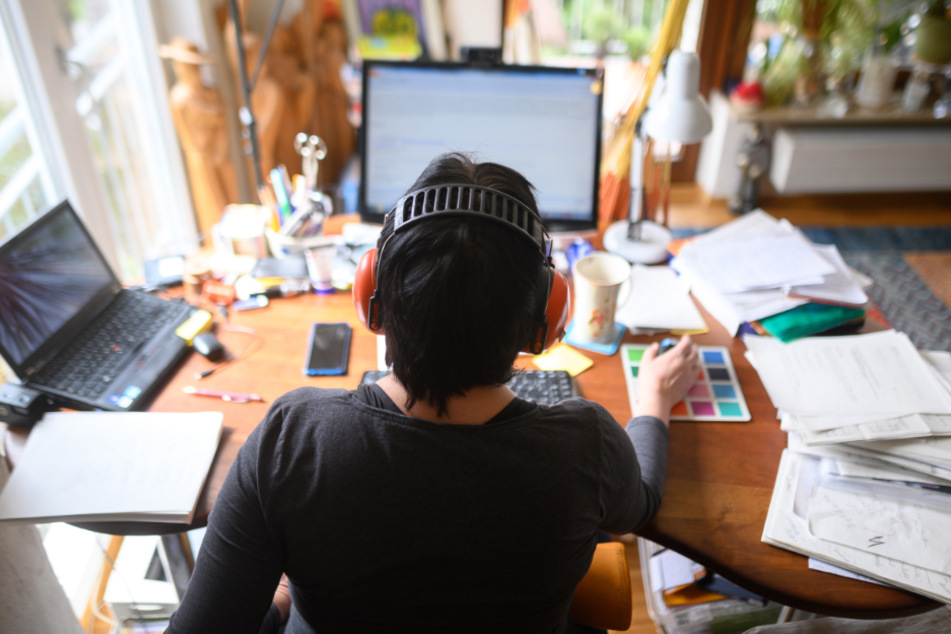Eine Frau arbeitet mit Hörschutz im Homeoffice.