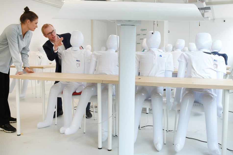 In einem Labor-Klassenzimmer mit 30 aufblasbaren Puppen sprechen Lara Möller, Ingenieurin für Energie und Gebäudetechnik, und Stephan Schönfelder von der Hochschule für Technik, Wirtschaft und Kultur (HTWK) über das UV-C-Forschungsprojekt.