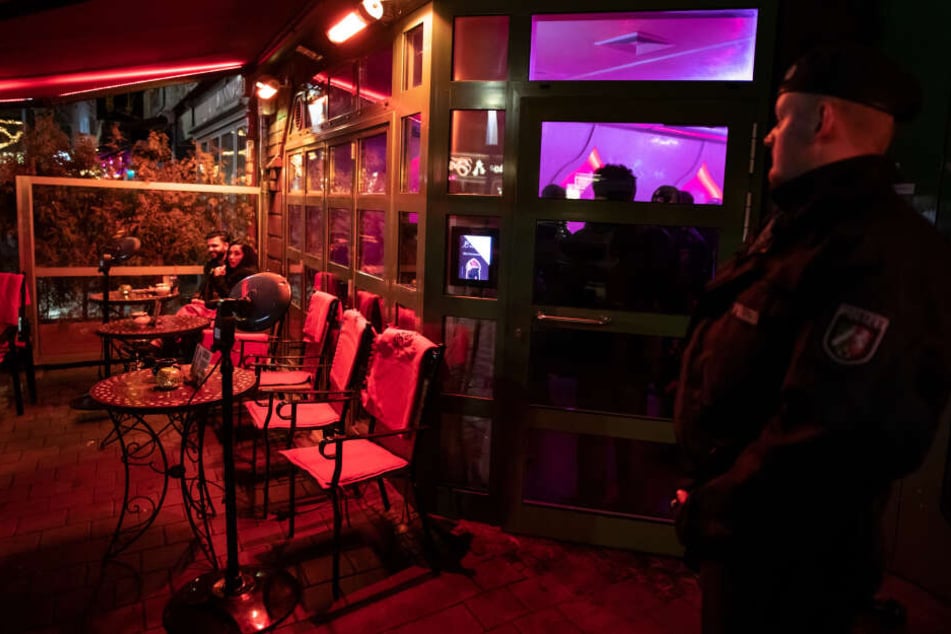 Ein Polizist sichert während einer Razzia eine Shisha-Bar.