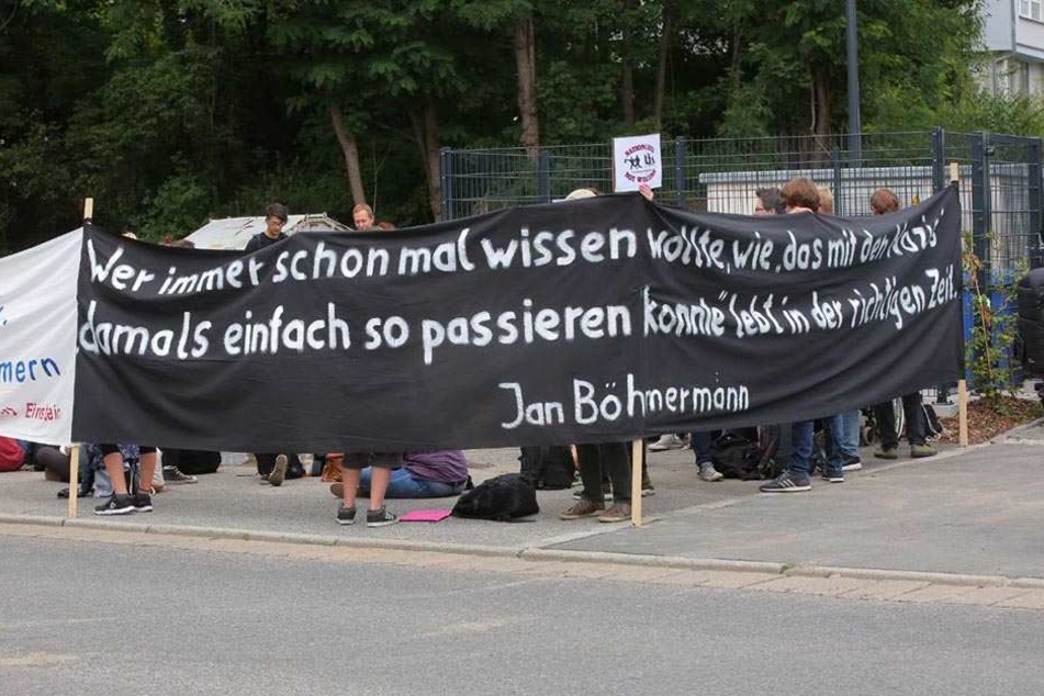 Protestierende halten ein Banner nach oben.