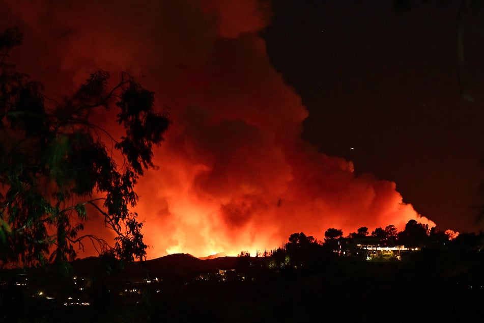 Smoke and flames from the Palisades Fire burn toward the Encino neighborhood of Los Angeles, California, January 10, 2025, triggering new evacuation orders.