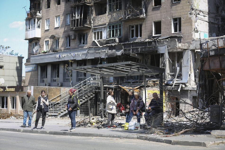 Anwohner stehen vor einem zerstörten Gebäude in der ukrainischen Hafenstadt Mariupol.
