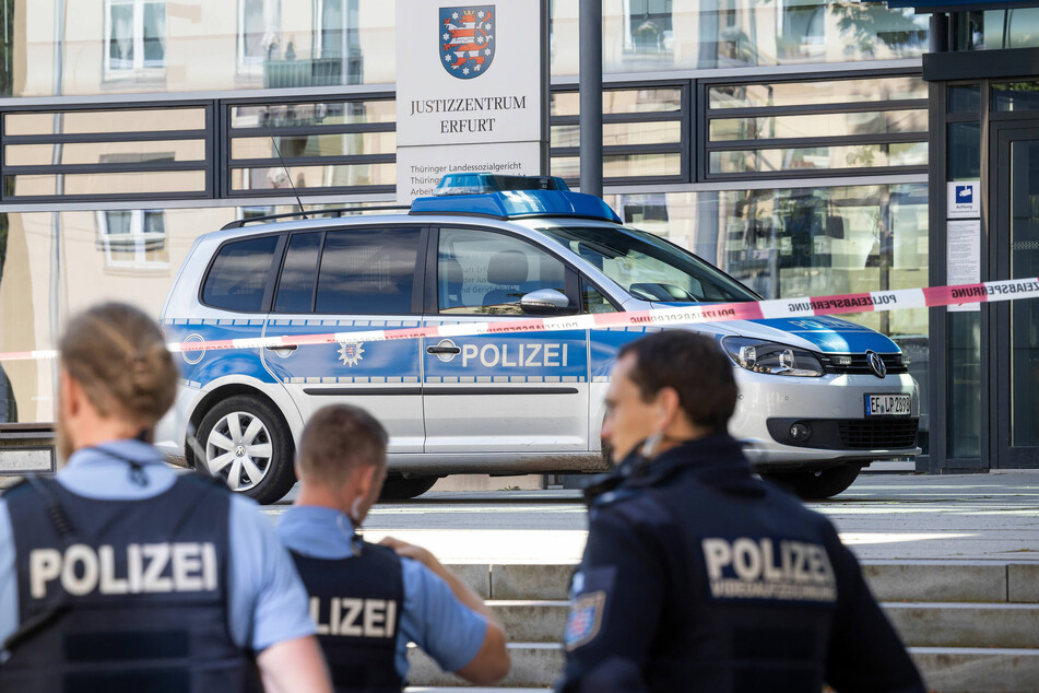 Polizisten stehen nach einer Bombendrohung vor dem Justizzentrum Erfurt.