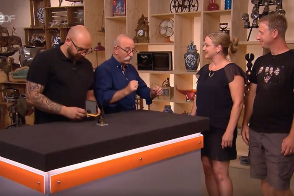 Experte Sven Deutschmanek, Moderator Horst Lichter und das Ehepaar Hahn warten auf die Expertise zu den beiden Blechspielzeugen.