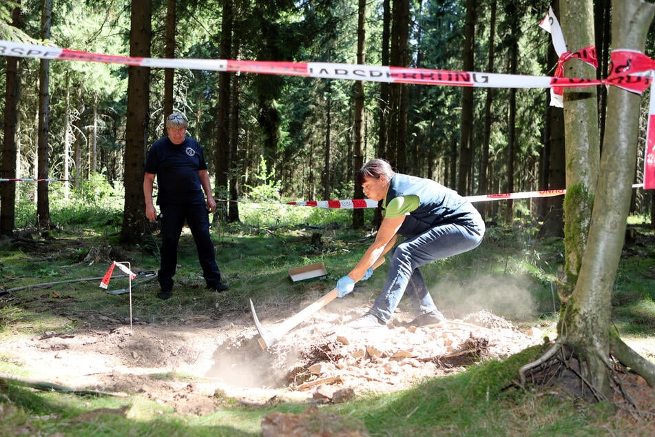 Kriminalhauptkommissarin Diana Bonk (53) mit der Spitzhacke am Grab.