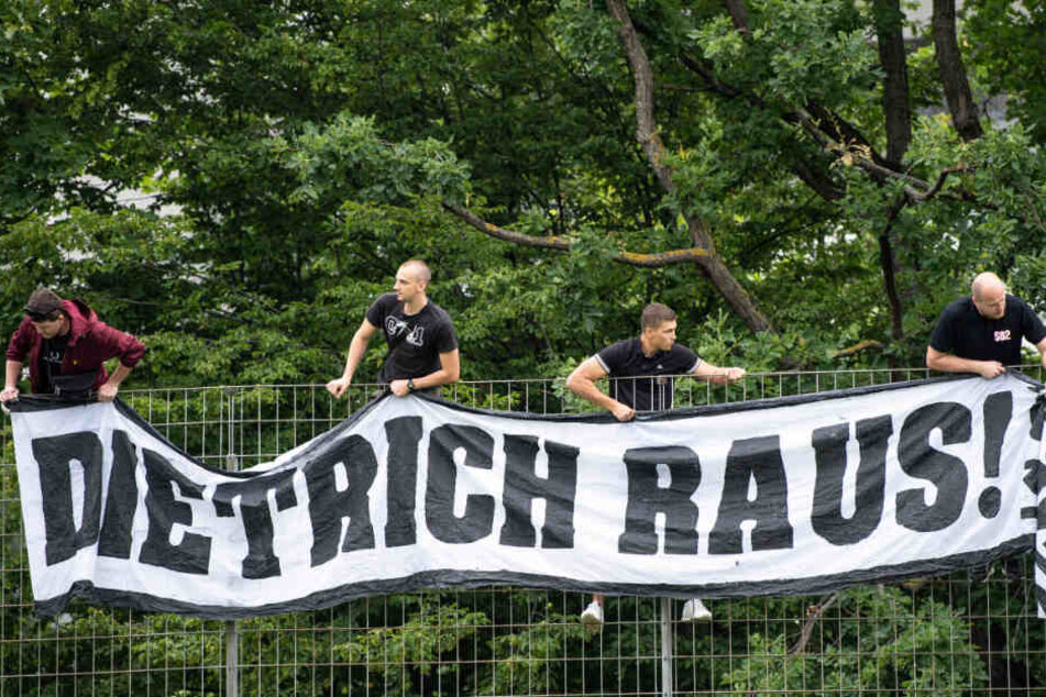 VfB-Fans hängen beim Trainingsauftakt in die Zweitliga-Saison ein Banner mit "Dietrich Raus!" am Trainingsgelände auf.