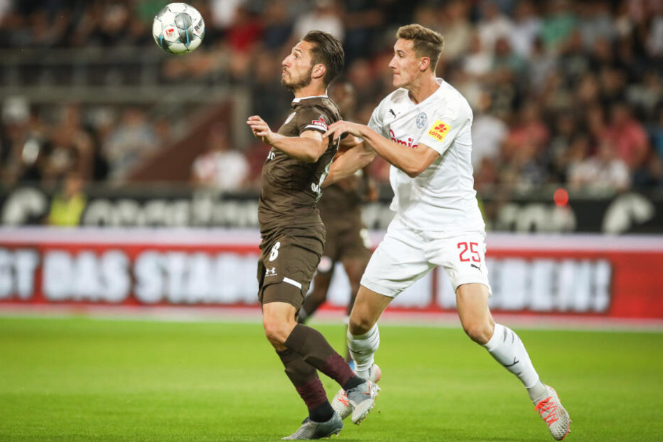 Mit seinem Körper schirmt der Stürmer den Ball vor seinem Gegenspieler ab.