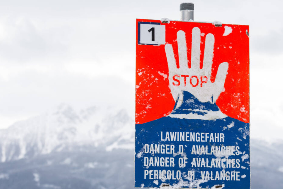 Ein Warnschild mit der Aufschrift "Stop- Lawinengefahr" ist im Raum Innsbruck zu sehen.